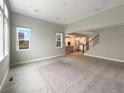 Spacious, bright living room with large windows, an open floor plan, and access to the kitchen at 11650 Lewiston Ct, Commerce City, CO 80022