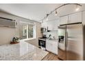 Bright kitchen featuring stainless steel appliances, granite countertops, and sleek white cabinetry for a modern cooking space at 1349 Race St # 5, Denver, CO 80206