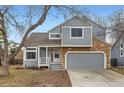 Inviting home with a stone-accented front, a covered porch, and an attached two-car garage at 2358 Dogwood Cir, Louisville, CO 80027
