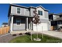 Charming two-story home with gray siding, a two-car garage, and landscaped front yard at 2351 Monte Vista St, Fort Lupton, CO 80621