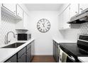 Well-lit modern kitchen with sleek black appliances and tiled backsplash at 1313 N Williams St # 301, Denver, CO 80218