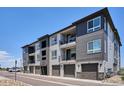 Attractive townhome complex with a gray exterior and individual garages at 16860 Askins Loop # 102, Parker, CO 80134