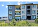 Multi-story townhome with balconies, gray exterior, and lush landscaping at 16860 Askins Loop # 102, Parker, CO 80134