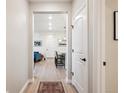 Hallway with hardwood-style floors leading to the bright, open living area at 16860 Askins Loop # 102, Parker, CO 80134