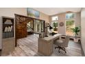Bright home office space with a wood desk, built-in bookcase, wood floors, large windows and staircase at 15175 Rainbow Dr, Sedalia, CO 80135