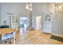 Bright foyer with a view of the stairs, dining room, and a white console table with decorative mirror at 5532 S Valdai Way, Aurora, CO 80015