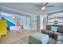 Open-concept living room with a ceiling fan, couch, and adjacent play area, with luxury vinyl floors at 5532 S Valdai Way, Aurora, CO 80015