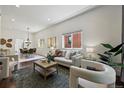 Bright living room with modern furnishings and ample natural light, open to dining area at 1612 S Logan St, Denver, CO 80210