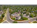 An aerial view of a suburban neighborhood showcasing a property with lush greenery and mature trees at 12814 Forest Cir, Thornton, CO 80241