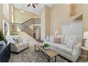 Bright living room showcasing soaring ceilings, a staircase, and neutral décor with comfortable seating at 12814 Forest Cir, Thornton, CO 80241