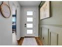 Bright foyer with stylish decor, featuring paneled walls, and a modern front door with frosted windows at 4040 Eaton Park St, Aurora, CO 80019