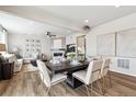 Dining area with a modern table, chairs, and views into a cozy living room with a fireplace at 104 Wooten Ave, Brighton, CO 80601