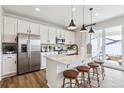 Bright kitchen with stainless steel appliances, white cabinets, and a quartz island at 104 Wooten Ave, Brighton, CO 80601