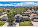 An aerial view shows the home's landscaped yard, mountain views, and neighborhood setting at 1977 S Urban St, Lakewood, CO 80228