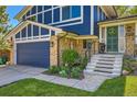 Welcoming front entrance with brick accents, lush landscaping, and charming entryway details at 1977 S Urban St, Lakewood, CO 80228