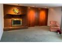 Living room with brick fireplace and wood paneled wall at 5922 S Otis Ct, Littleton, CO 80123