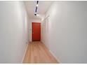 Hallway featuring a red door, closet and new flooring at 700 N Washington St, Denver, CO 80203