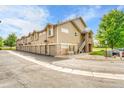 Row of condo garages and exterior stairs with stone accents under a bright blue sky at 3261 S Waco Ct # C, Aurora, CO 80013