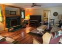 Inviting living room featuring a fireplace, wooden floors, piano and lots of natural light at 4393 Pima Rd, Indian Hills, CO 80454