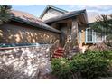 Charming entryway with wood stairs, stone accents, and lush landscaping detail at 23951 E Easter Pl, Aurora, CO 80016