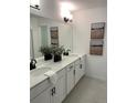 Bright bathroom featuring double vanity with white cabinets and stone countertop at 348 N. Geneva St, Aurora, CO 80010