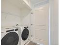Functional laundry area with white appliances and shelving at 348 N. Geneva St, Aurora, CO 80010