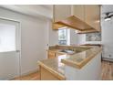 Efficient kitchen with stainless steel sink, blonde wood cabinets, and access to outside door at 1629 N Clarkson St # 13, Denver, CO 80218