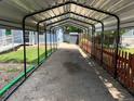 Metal carport covering a long driveway with grass and fence at 1738 Dallas St, Aurora, CO 80010