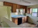 Functional kitchen with wooden cabinets, black appliances, and tile floor at 1738 Dallas St, Aurora, CO 80010