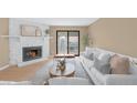 Cozy living room with a white stone fireplace, access to the balcony, and a modern design at 921 S Walden Street # 205, Aurora, CO 80017