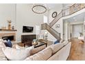 Spacious living room with high ceilings, fireplace, staircase, and modern decor at 3093 Belay Pt, Castle Rock, CO 80108