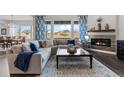 Bright living room featuring a fireplace, large windows, and a comfortable sectional sofa at 3093 Belay Pt, Castle Rock, CO 80108
