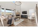 Open living room with a large window, high ceiling, and a cozy fireplace at 3093 Belay Pt, Castle Rock, CO 80108