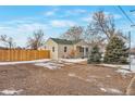 Charming single-story home featuring a gravel driveway, a new fence, a green roof, and mature landscaping at 6900 E 66Th Ave, Commerce City, CO 80022