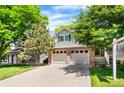 Two-story home with brick accents, a two-car garage, and a well-kept lawn and trees at 9916 Spring Hill Ln, Highlands Ranch, CO 80129