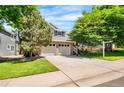 Two-story house featuring brick accents, a two-car garage, and landscaped front yard at 9916 Spring Hill Ln, Highlands Ranch, CO 80129