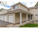 A home exterior with a three-car garage, covered entryway, and light-colored siding at 12406 E Pacific Cir # D, Aurora, CO 80014