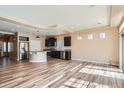 Open-concept kitchen with dark cabinetry, stainless steel appliances, hardwood floors, and a center island at 4625 Walden Ct, Denver, CO 80249