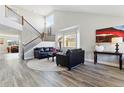 Bright living room with high ceilings, large windows, hardwood floors and staircase at 18130 Bolero Dr, Parker, CO 80134
