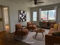 A brightly lit living room with stylish mid-century modern furnishings and hardwood floors at 5618 Carr St, Arvada, CO 80002