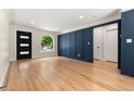 Open living room featuring hardwood floors, modern blue paneling, and recessed lighting at 1045 Locust St, Denver, CO 80220