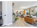 Bright, open-concept living space with hardwood floors, modern furnishings, and a view into the kitchen at 6364 Fulton St, Denver, CO 80238