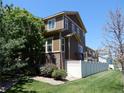 Exterior view featuring a well-maintained backyard, complemented by a white fence and tasteful landscaping at 7354 Benton St, Arvada, CO 80003