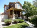 Inviting two-story home with a well-manicured lawn and landscaping, featuring a charming front porch at 7354 Benton St, Arvada, CO 80003
