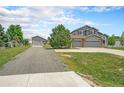 Two-story home featuring a three-car garage and detached garage, complemented by a well-maintained lawn at 16500 Timber Cove St, Hudson, CO 80642