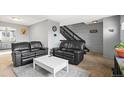 Cozy living area featuring black leather sofas, stairs, and neutral decor at 6838 S Broadway, Centennial, CO 80122