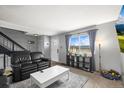 Inviting living room with comfortable black leather seating and natural light at 6838 S Broadway, Centennial, CO 80122