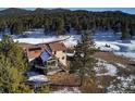 Stunning aerial view of home in a serene, snow-covered landscape with mature trees at 5371 Hazel Rd, Evergreen, CO 80439