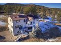 Beautiful home featuring solar panels and a multi-level deck, nestled in a wooded setting at 5371 Hazel Rd, Evergreen, CO 80439