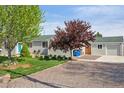 Charming single-story home with a well-manicured lawn and gravel driveway leading to the attached garage at 6245 W 53Rd Ave, Arvada, CO 80002